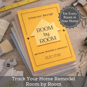 Op de afbeelding: Een geel softcover boek getiteld Interior Design ROOM by ROOM Decision Tracker & Checklist met een huisvormige afbeelding. De kaft bevat de tekst 123 Main Street Anywhere, US 12345 en een ster-vormig embleem For Every Room in Your Home.