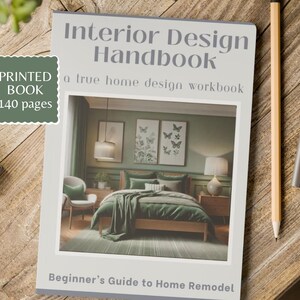 以下が含まれることがあります： 「Interior Design Handbook」というタイトルの140ページの印刷された本で、家のインテリアシーンが特徴です。鉛筆とペンが本の隣の木製の表面に置かれています。この本は、家のリフォームの初心者向けガイドです。