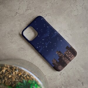May include: A navy blue phone case with a cityscape silhouette and a starry night sky design. The city lights are visible in the buildings.