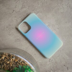 Pu&ograve; includere: Una custodia per telefono blu chiaro con un gradiente di rosa e blu. La custodia ha un ritaglio per l'obiettivo della fotocamera.