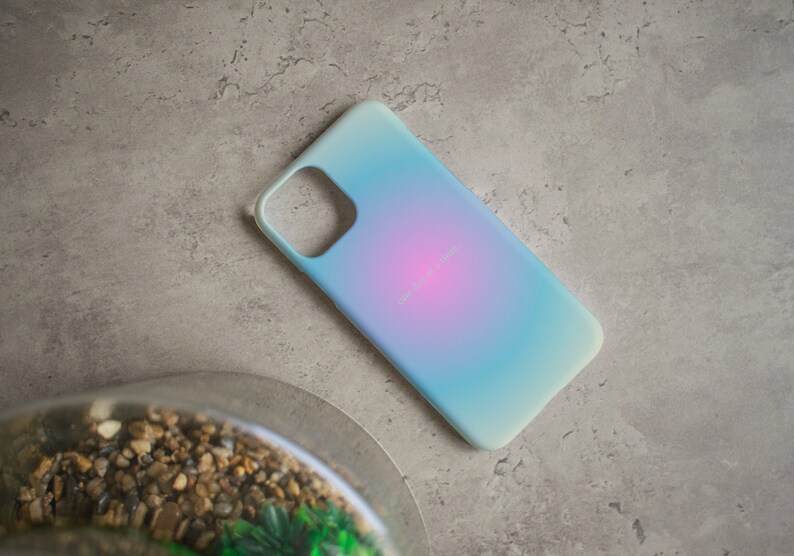 Pu&ograve; includere: Una custodia per telefono blu chiaro con un gradiente di rosa e blu. La custodia ha un ritaglio per l'obiettivo della fotocamera.
