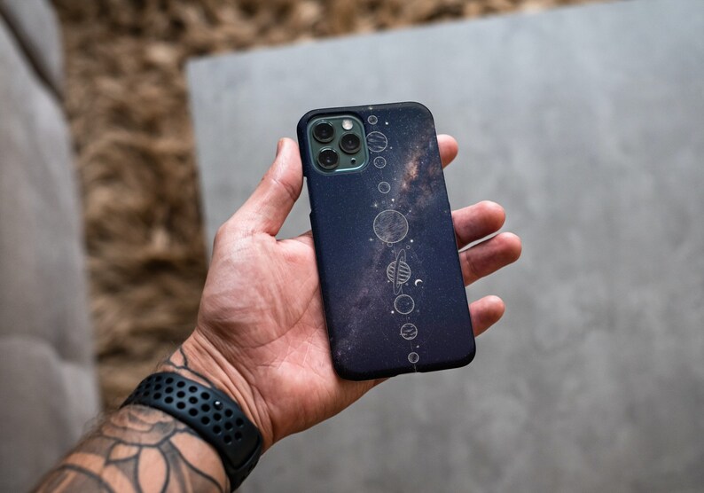 May include: A black phone case with a galaxy print and a white outline of the solar system.