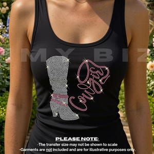 May include: A black tank top featuring a rhinestone graphic of a tall boot and the word Cowgirl in pink script. The boot is decorated with clear rhinestones and pink bands around the ankle. The design is centred on the chest of the garment.
