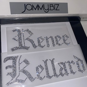 Puede incluir: Dos transferencias de diamantes de imitaci&oacute;n termoadhesivos sobre l&aacute;minas adhesivas transparentes. La l&aacute;mina superior muestra el nombre Renee y la inferior el nombre Kellard, ambos en fuente g&oacute;tica. El texto JAMMY.BIZ es visible arriba.