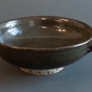 May include: A dark brown ceramic serving bowl with two handles and a white speckled base.