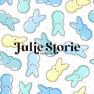 Pode incluir: Um padrão sem costura com marshmallows em forma de coelho de cor azul pastel, amarelo e azul claro sobre um fundo branco com textura pontilhada. O texto "Julie Storie Designs" está centralizado no padrão.