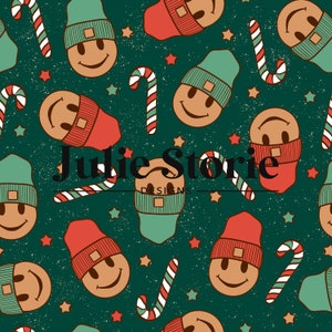 May include: A seamless pattern featuring a green background with red and white candy canes, stars, and smiling gingerbread men wearing red and green knit hats. The text "Julie Storie Designs" is centered in the pattern.