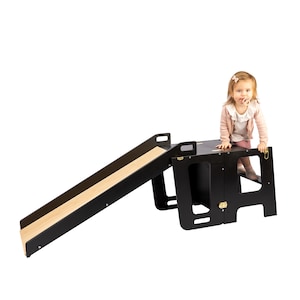 Adventurous toddler climbs up the slide attached to a Learning Tower. Steping Stool enhancing playtime.