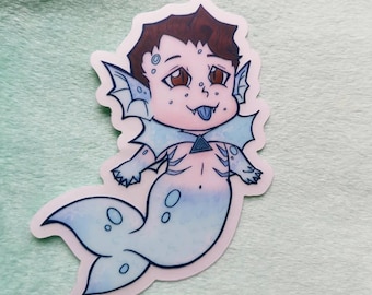 May include: A sticker of a cartoon mermaid-like character with brown hair, blue skin, and a blue tongue. The character has a light blue tail and a triangle pendant.
