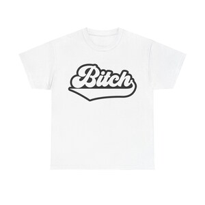 Puede incluir: Camiseta blanca con la palabra "Bitch" en negro, con una fuente de estilo retro. La palabra está delineada en negro y tiene un diseño curvo y estilizado debajo. Prenda de vestir unisex.