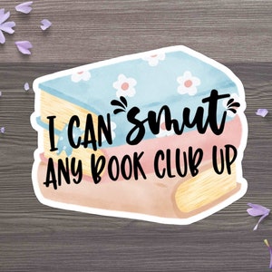 Può includere: Un adesivo raffigurante una pila di libri con la scritta "I can't smut any book club up." Il libro in alto è azzurro chiaro con fiori bianchi, quello centrale è rosa e quello in basso è marrone. Petali di fiori viola circondano l'adesivo.