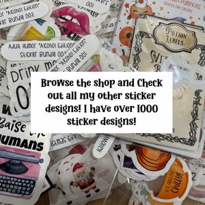 May include: A close-up of a variety of colorful stickers in a clear plastic bag. The stickers feature different designs, including a typewriter, a pumpkin, a witch's cauldron, and a Christmas Santa. The text "Browse the shop and Check out all my other sticker designs! I have over 1000 sticker designs!" is written in white text on a black background.
