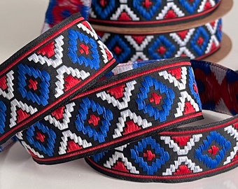 Könnte beinhalten: Rot-weiß-blaues gemustertes Band mit geometrischem Design. Das Band ist auf schwarzem Grund gewebt und zeigt ein sich wiederholendes Muster aus Rauten und Kreisen.
