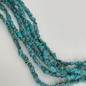 May include: A strand of turquoise chip beads, featuring a light blue color with dark brown veining. The beads are irregular in shape and size, creating a natural and rustic look.