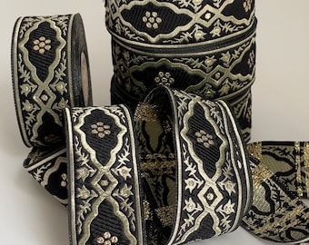 May include: Black and gold trim with a repeating geometric pattern. The trim is made of woven fabric and has a subtle sheen.