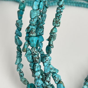 May include: A strand of turquoise chip beads, featuring a light blue color with dark brown veining. The beads are irregular in shape and size, creating a natural and rustic look.