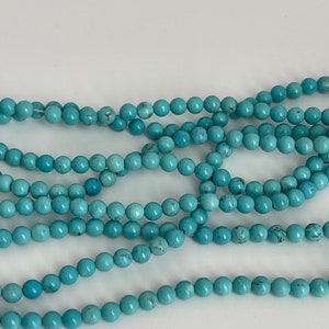 May include: A strand of turquoise blue beads, perfect for jewelry making or crafting.