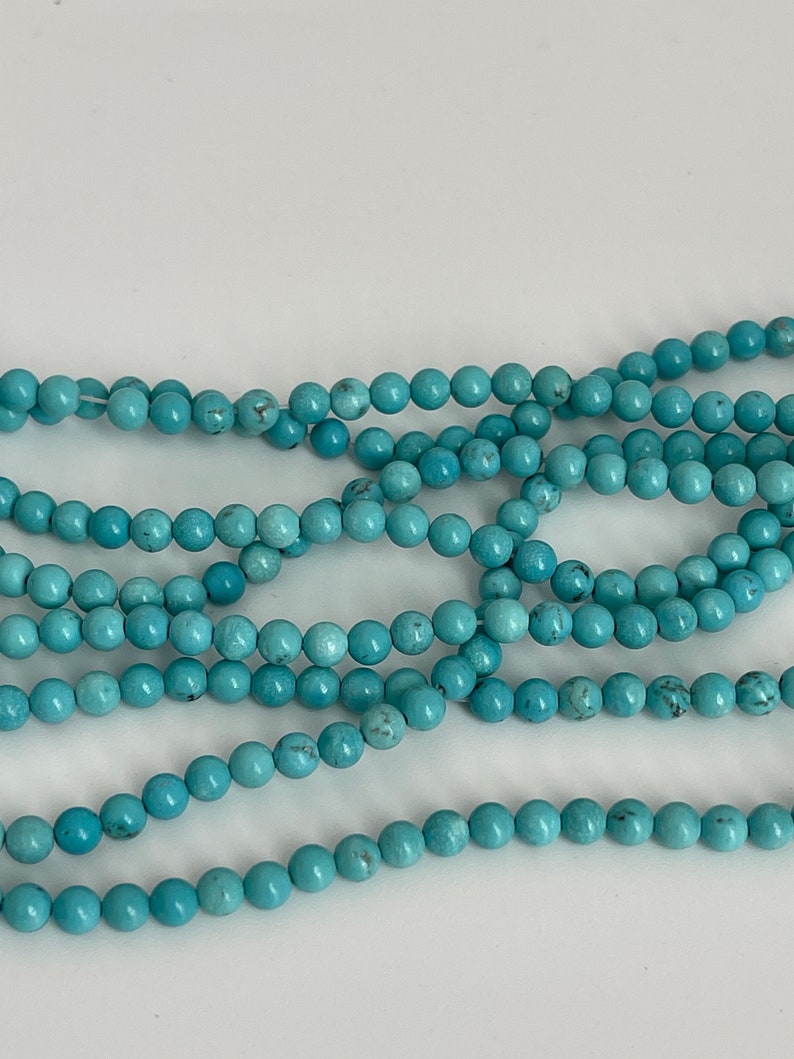 May include: A strand of turquoise blue beads, perfect for jewelry making or crafting.