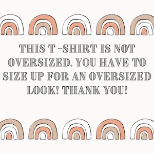 May include: White background with a graphic of five rainbow arches at the top and five rainbow arches at the bottom. The text "THIS T-SHIRT IS NOT OVERSIZED. YOU HAVE TO SIZE UP FOR AN OVERSIZED LOOK! THANK YOU!" is in black text.