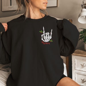 May include: Black sweatshirt with a white skeleton hand making a rock and roll sign with the text "Stay Merry" in red.