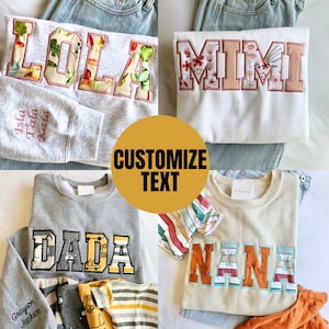 May include: Four different sweatshirts with customizable text. The sweatshirts are in various colors, including gray, white, and beige. The text on the sweatshirts includes "Lola", "Mimi", "Dada", and "Nana".