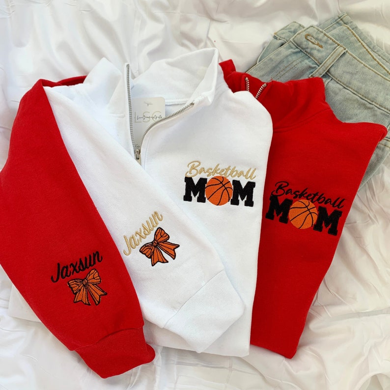May include: Two red and white sweatshirts with a basketball and the text "Basketball Mom" and "Jaxsun" embroidered on them.