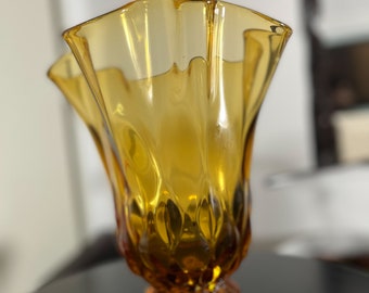 May include: A amber glass vase with a ruffled top and a textured, faceted base.