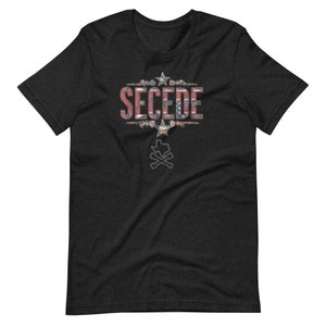 Puede incluir: Camiseta gris oscuro con la palabra "SECEDE" en un diseño desgastado inspirado en la bandera. El diseño incluye estrellas y un contorno de Texas con huesos cruzados. Camiseta de manga corta y cuello redondo.