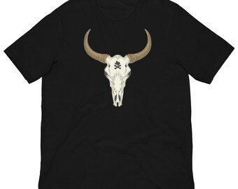 May include: Black t-shirt featuring a detailed illustration of a bull skull with long, curved horns. The skull is white with a black and white symbol on the forehead. The horns are tan. The shirt is a short-sleeved crew neck.