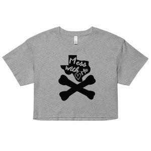 May include: A grey crop top with a black graphic. The design features the Texas state outline, the words "Mess with Me" and a heart, plus crossed bones. The top has short sleeves and a crew neck. A casual, statement piece.