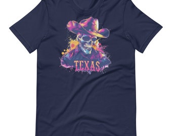 Puede incluir: Camiseta azul marino con una calavera colorida con sombrero de vaquero. La calavera está representada con tonos vibrantes de rosa, amarillo y azul, con la palabra "TEXAS" debajo. El diseño tiene un efecto acuarela.