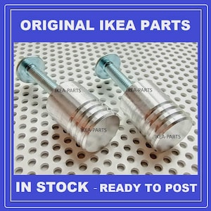 May include: Two silver-colored IKEA furniture parts with threaded rods and cylindrical bodies. The parts are labeled "IKEA-PARTS" and are displayed against a perforated metal background. The image includes the text "ORIGINAL IKEA PARTS" and "IN STOCK - READY TO POST".
