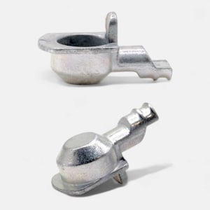 May include: Two silver metal parts, one with a curved top and a handle, the other with a rounded top and a short handle.