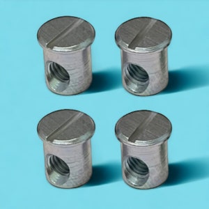 May include: Four silver-colored metal threaded inserts with a slotted top. The inserts are designed to be used in wood or plastic.