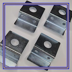 May include: Four silver-colored metal brackets with a rectangular base, a curved angled support, and a circular hole. Each bracket has two smaller holes. The brackets are arranged on a white surface.