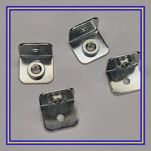 May include: Four silver metal right-angle brackets, each with a circular nut and a mounting hole. These brackets are designed to join two surfaces at a 90-degree angle. The image is framed with a blue and yellow border.