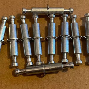May include: Ten silver metal push-to-connect fasteners with a threaded end and a ring around the centre.