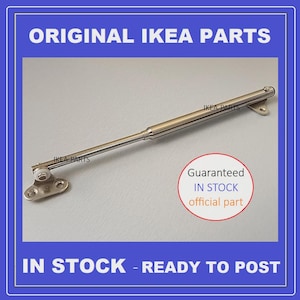 Könnte beinhalten: Ein silberfarbenes IKEA-Möbelscharnier mit Montageplatten und einem zylindrischen Körper. Der Text "ORIGINAL IKEA PARTS" und "IN STOCK - READY TO POST" sind sichtbar.
