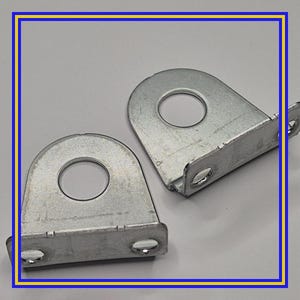 May include: Two silver-colored metal brackets with a rounded top and a circular hole. Each bracket has two smaller holes at the bottom and a small tab on the side. The brackets are displayed against a light gray background.