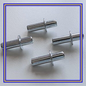 May include: Four small, silver-colored metal dowel pins with a cylindrical body and a circular flange on each end. The pins are arranged on a white surface, with a blue and yellow border.