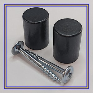 Może przedstawiać: Dwa czarne drewniane gałki do szafek o cylindrycznym kształcie, połączone z dwiema srebrnymi śrubami. Gałki są ciemne i gładkie, a śruby mają płaską główkę i gwintowany trzpień. Przedmioty są ustawione na białym tle.