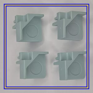 May include: Four pale blue plastic components, each with a distinctive shape and a circular indentation. They are arranged in a square formation against a white background, framed by a blue and yellow border.