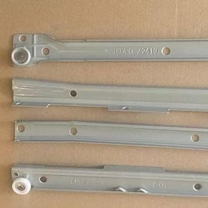 May include: Four silver drawer slides with metal rollers. The slides are labelled "IKEA G 72419" and "HO".