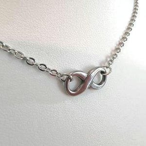 May include: A silver infinity symbol necklace with a delicate chain.