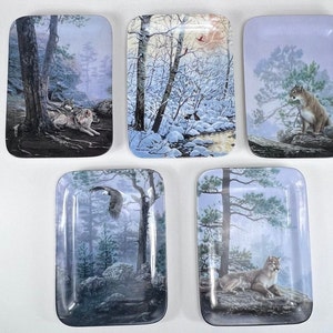 May include: Five rectangular decorative trays with wildlife scenes. The trays feature images of a wolf, a cougar, an eagle, and a winter landscape with birds. The trays have a glossy finish and are likely made of ceramic or a similar material.