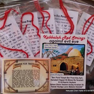 Könnte beinhalten: Eine Sammlung religiöser Artikel, darunter rote Schnüre, Gebetskarten und eine Karte mit dem Text "Gebet für Reisende". Die Artikel sind in transparenten Plastiktüten verpackt und weisen hebräischen Text und Illustrationen auf.