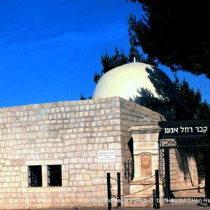 May include: A white stone building with a domed roof and a gate with the Hebrew text "Kever Ha-Amun" (Tomb of the Faithful) above it.