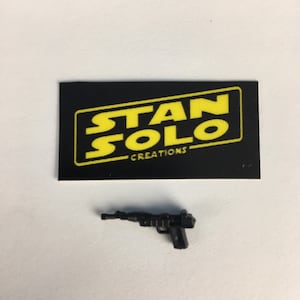 May include: Black plastic toy gun with a black and yellow card that says "Stan Solo Creations".