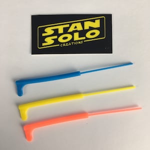 May include: Three lightsaber blades in blue, yellow, and orange. The blades are made of plastic and are approximately 25 cm long. The blades are for use with a lightsaber prop.