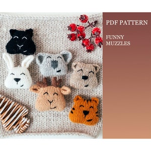 Puede incluir: Patrones de caras de animales de punto para un proyecto de manualidades. Los patrones incluyen un gato negro, un conejo blanco, un koala gris, un oso marrón, un ciervo marrón y un tigre naranja. Los patrones están sobre un fondo de punto beige con bayas rojas.